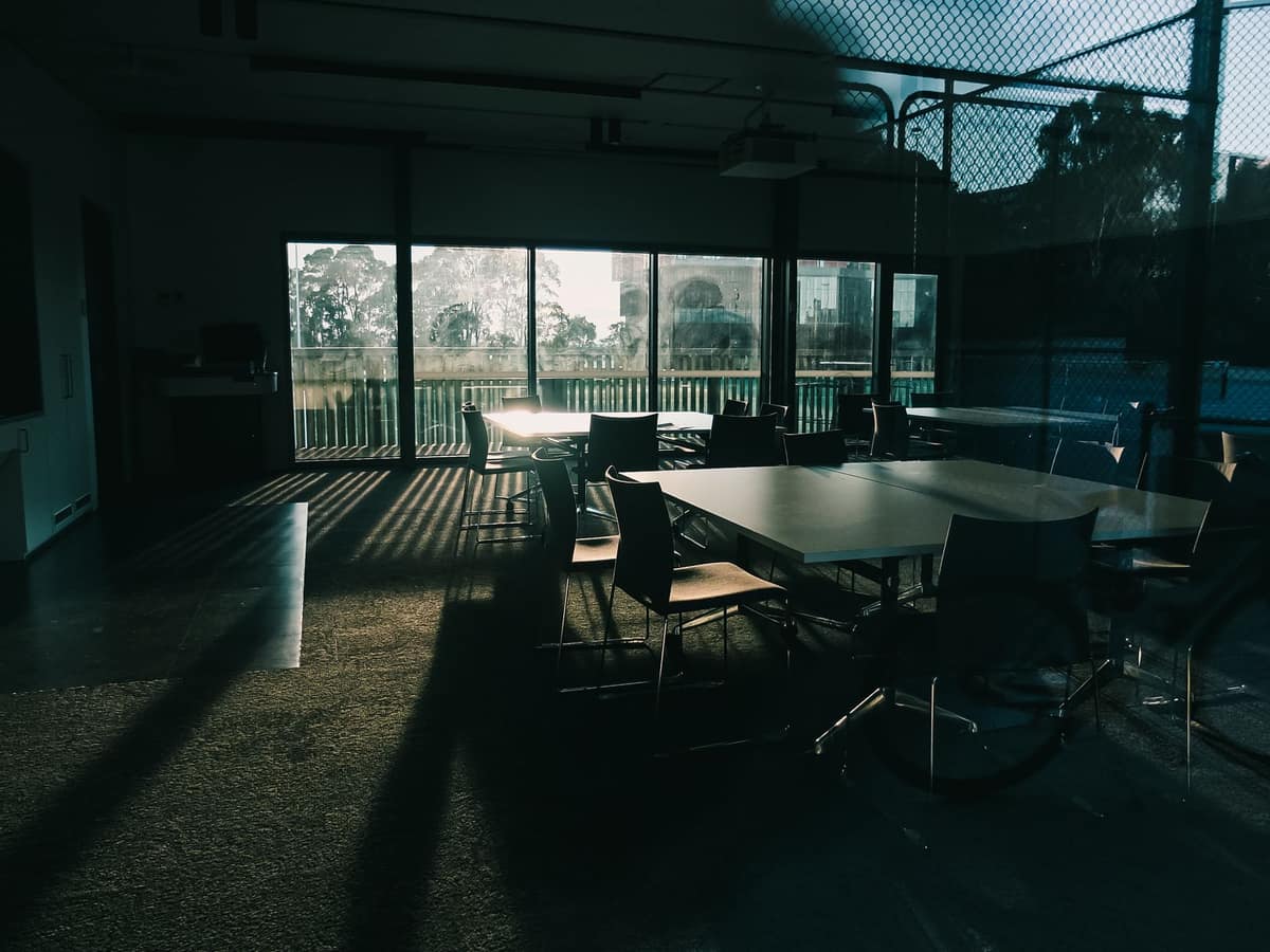 A serene empty conference room with dramatic sunlight and stylish furniture.